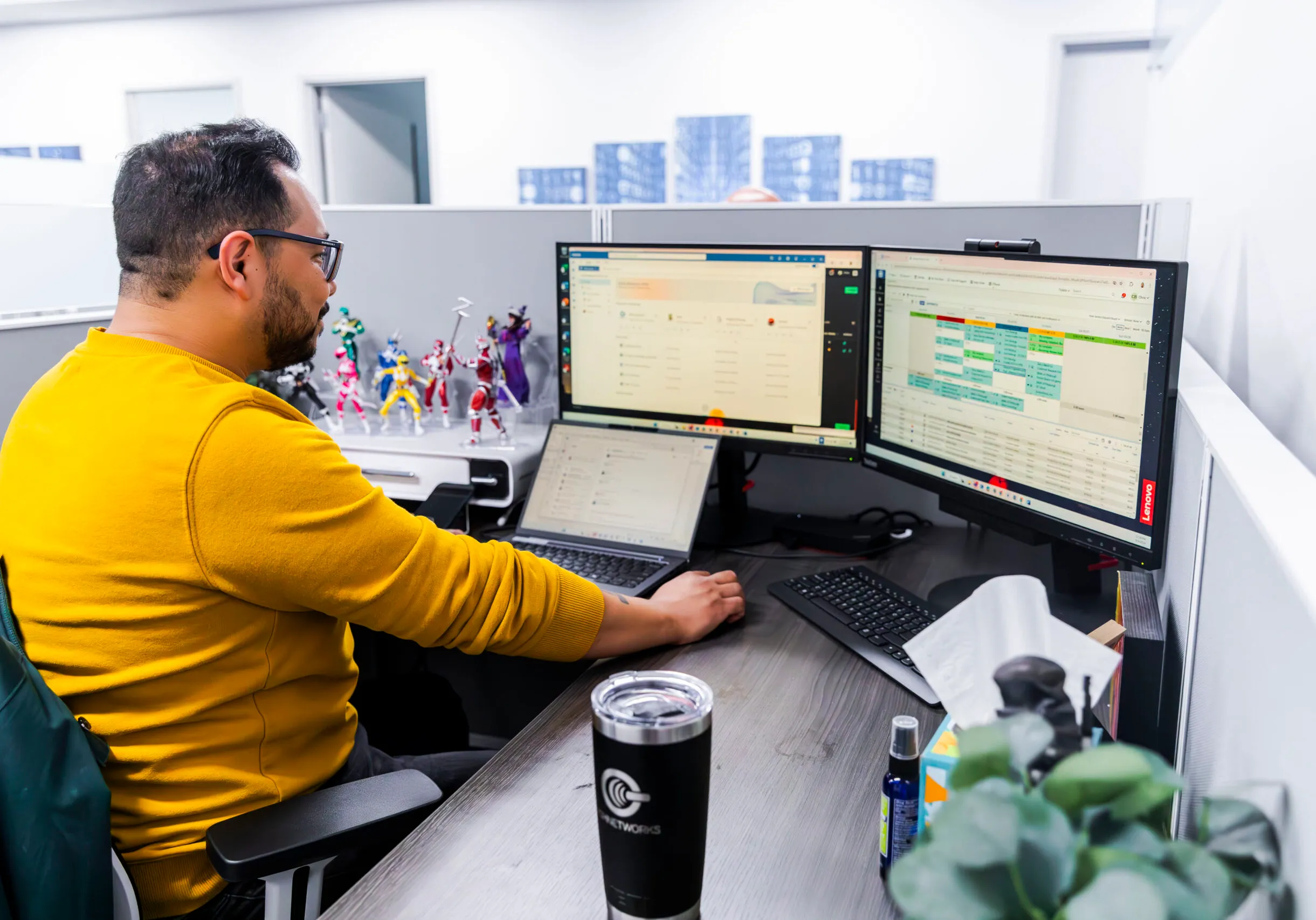 A PGH Networks engineer monitoring security dashboards across dual screens.