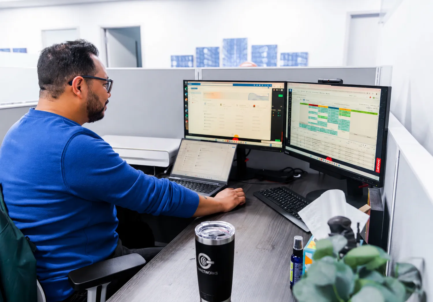 A PGH Networks engineer monitoring security dashboards across dual screens.