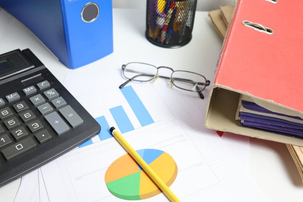 Desk with calculator, charts, and binders